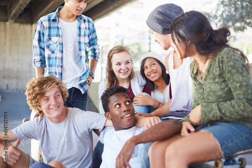 Photos Teenage friends hanging out talking at skate park