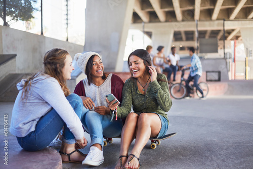 Bild auf Leinwand Teenage girls on skateboard texting and hanging out at skate park