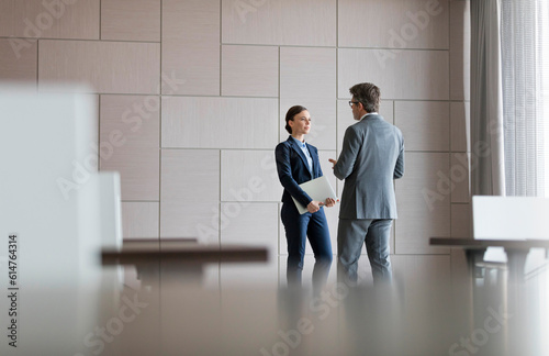 Businessman and businesswoman talking in conference room