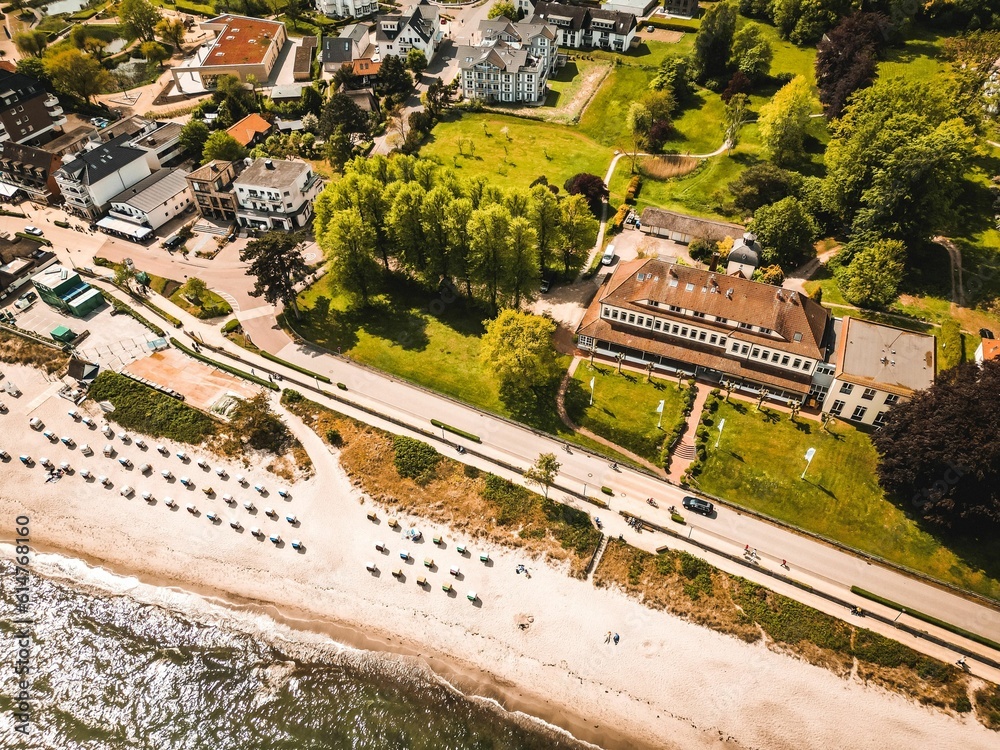 Aerial view of a hotel on a green beach against sea waves on a sunny day