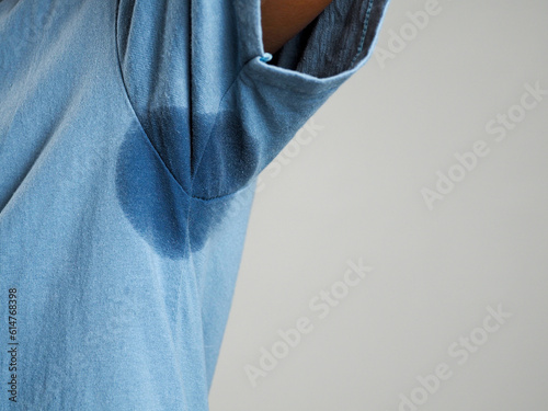 Sweating, wet armpits on a man with a bad body odor or foul odor use of deodorant