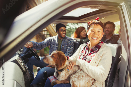 Portrait smiling woman with dog on lap in car with friends