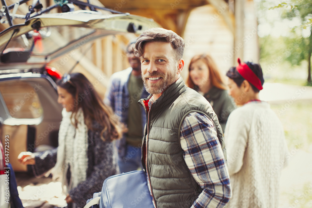 Portrait smiling man with friends unloading car