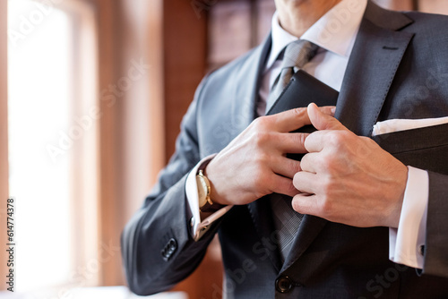 Close up businessman retrieving wallet from suit jacket photo