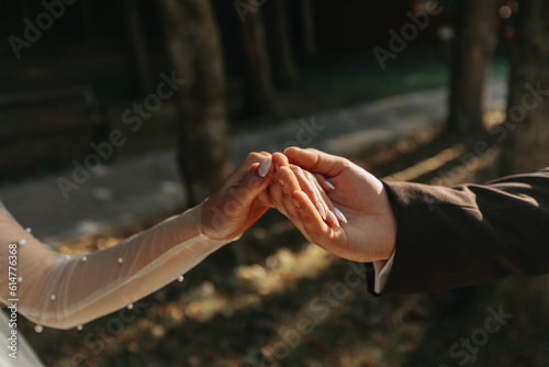 A beautiful luxury wedding. Close-up of bride and groom's hands. The groom holds the bride's hand. Wedding ring