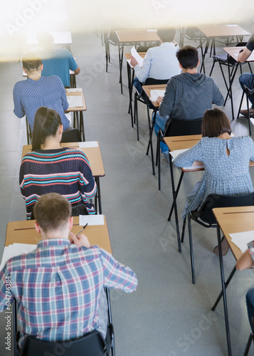Fotografie College students taking test at desks in classroom