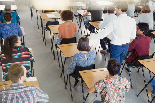 Bild auf Leinwand Professor collecting test from students in classroom