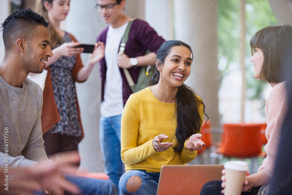 Fotografie Smiling college students talking and drinking coffee in commons
