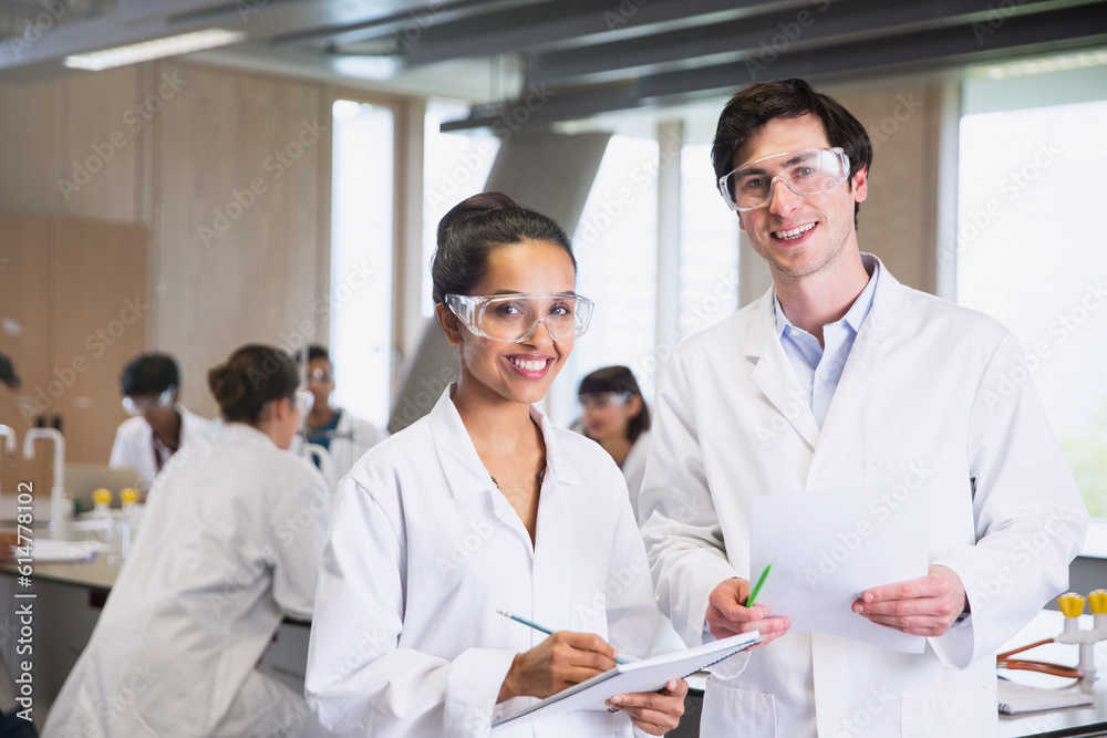 Portrait confident college students in lab coats in science laboratory classroom Portrait confident college students in lab coats in science laboratory classroom