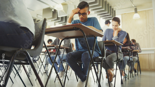 College students taking test at desk in classroom photo