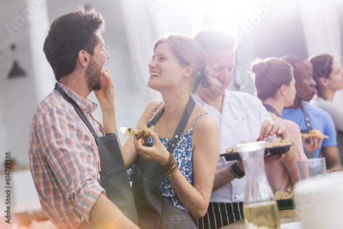 Wife feeding husband in cooking class kitchen