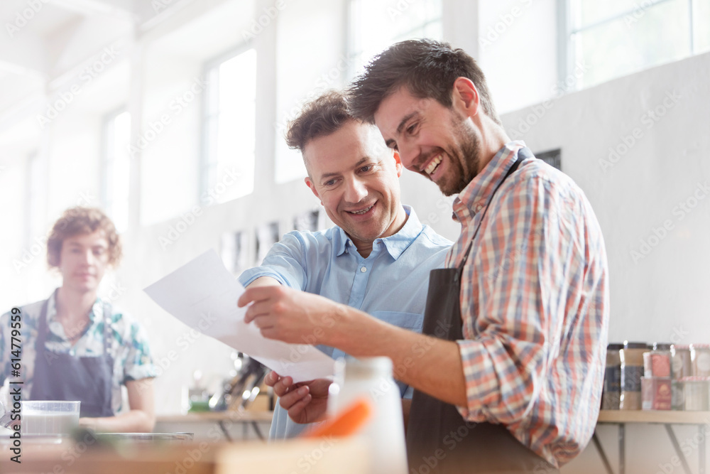 Fototapeta premium Male students with recipe in cooking class kitchen