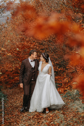 Wedding couple on a walk in the autumn park, medium portrait, place for text © Vasil