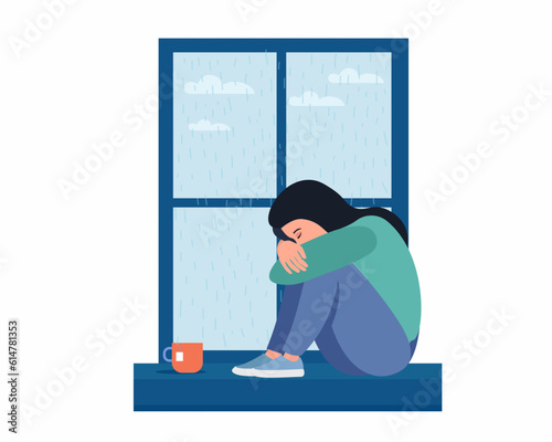 Sad woman is sitting near the windowsill female depression. Loneliness, sadness concept