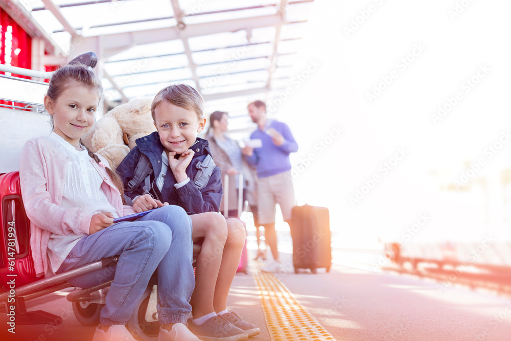Portrait smiling brother and sister waiting outside airport Portrait smiling brother and sister waiting outside airport