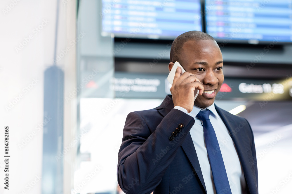 Businessman talking on cell phone in airport Businessman talking on cell phone in airport