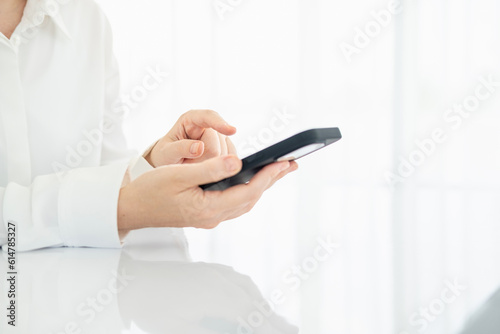 Hands of a woman who operates a smartphone