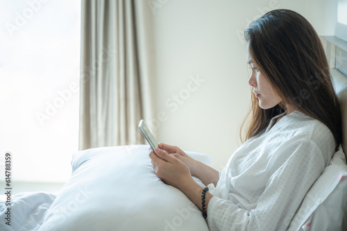 Sadness Asian woman using smartphone and waiting someone for call her back.