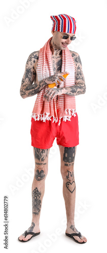 Tattooed man applying sunscreen cream on white background