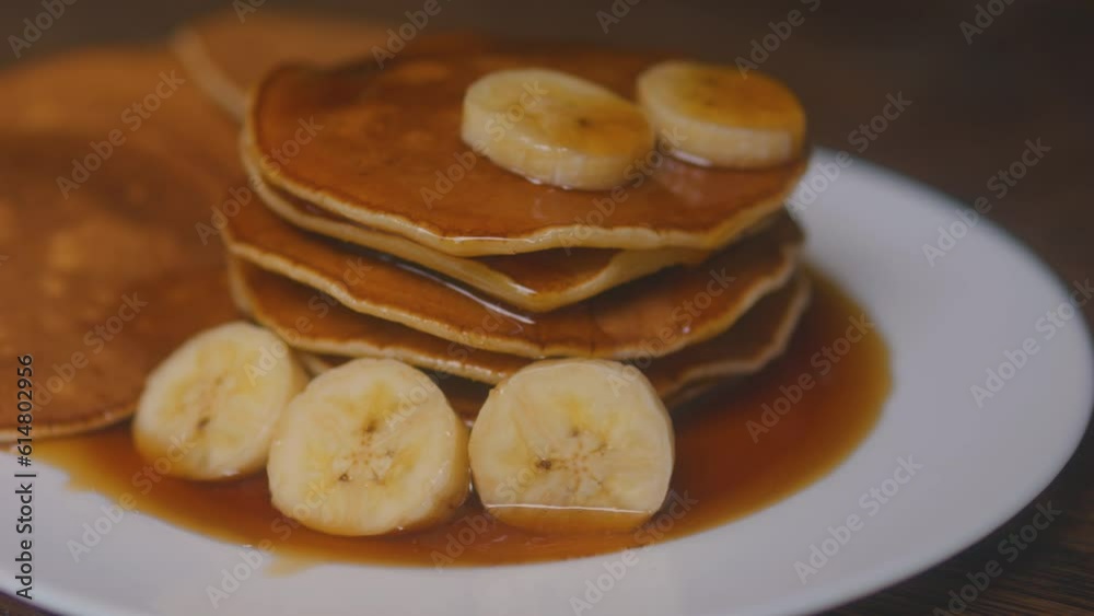 Stack of pancakes with banana slices and maple syrup honey caramel on plate. Stack of pancakes with banana slices and maple syrup honey caramel on plate.