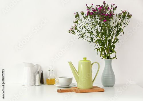 Composition with teapot  cup and different items on white table