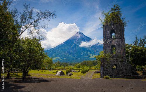 volcano in eruption next to old bell tower demolished by lava