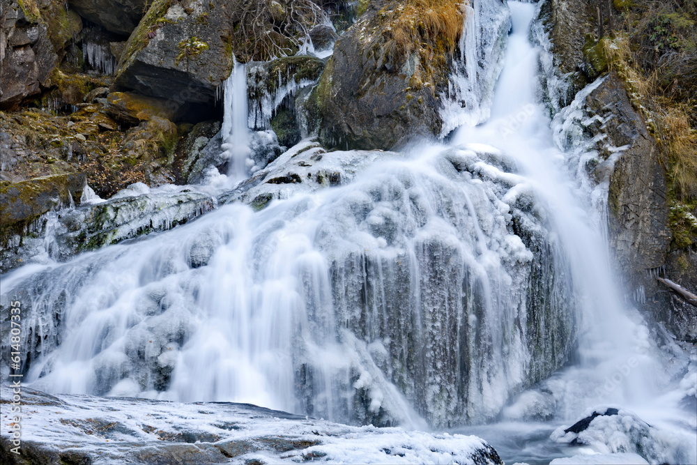 Russia. South of Western Siberia. One of the most beautiful waterfalls of the Altai Mountains on the Karasu River near the village of Chibit on the Chui tract, chained with ice of autumn frosts. Russia. South of Western Siberia. One of the most beautiful waterfalls of the Altai Mountains on the Karasu River near the village of Chibit on the Chui tract, chained with ice of autumn frosts.