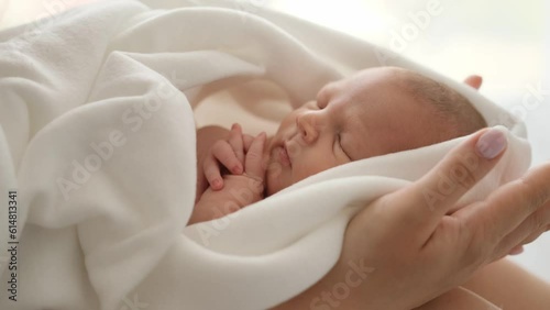 Wallpaper Mural Adorable newborn baby sleeping on his mother hands. Closeup view of infant child swaddled in blanket napping and his mom cares about him Torontodigital.ca