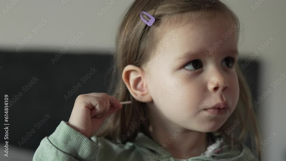 caucasian girl toddler use cotton swab stick bud to clean her ear caucasian girl toddler use cotton swab stick bud to clean her ear