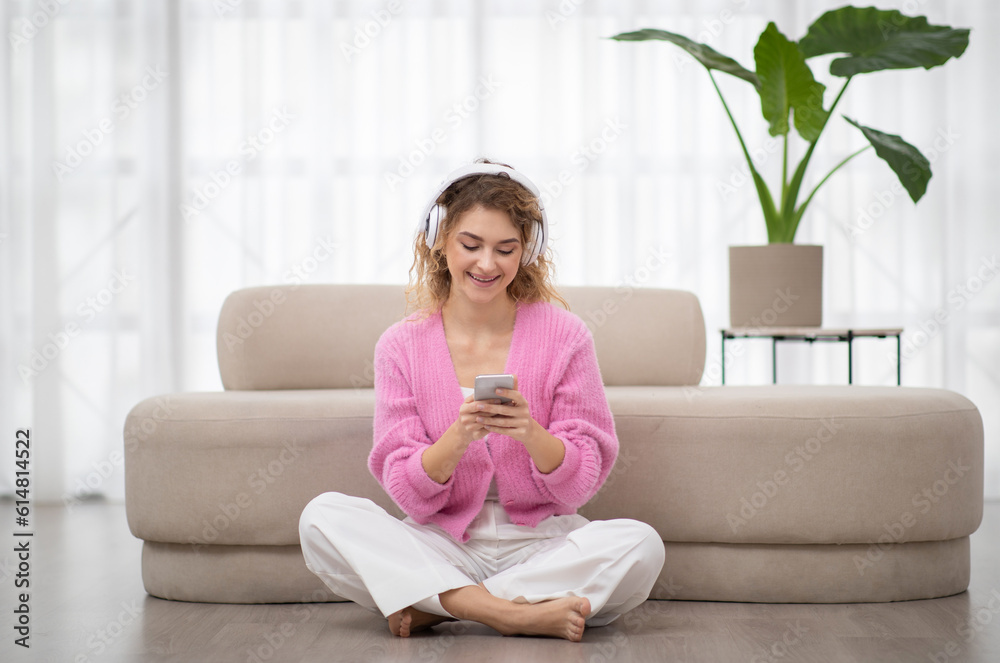 Smiling Woman Browsing Music Streaming Services Or Messaging On Smartphone At Home Smiling Woman Browsing Music Streaming Services Or Messaging On Smartphone At Home