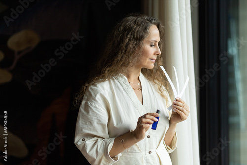 Girl perfumer chooses a fragrance on blotters, portrait. The concept of aromatherapy and perfumes made of aromatic oils