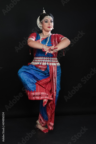 Woman performing Odissi dance in colorful costume. Indian classical dance forms.