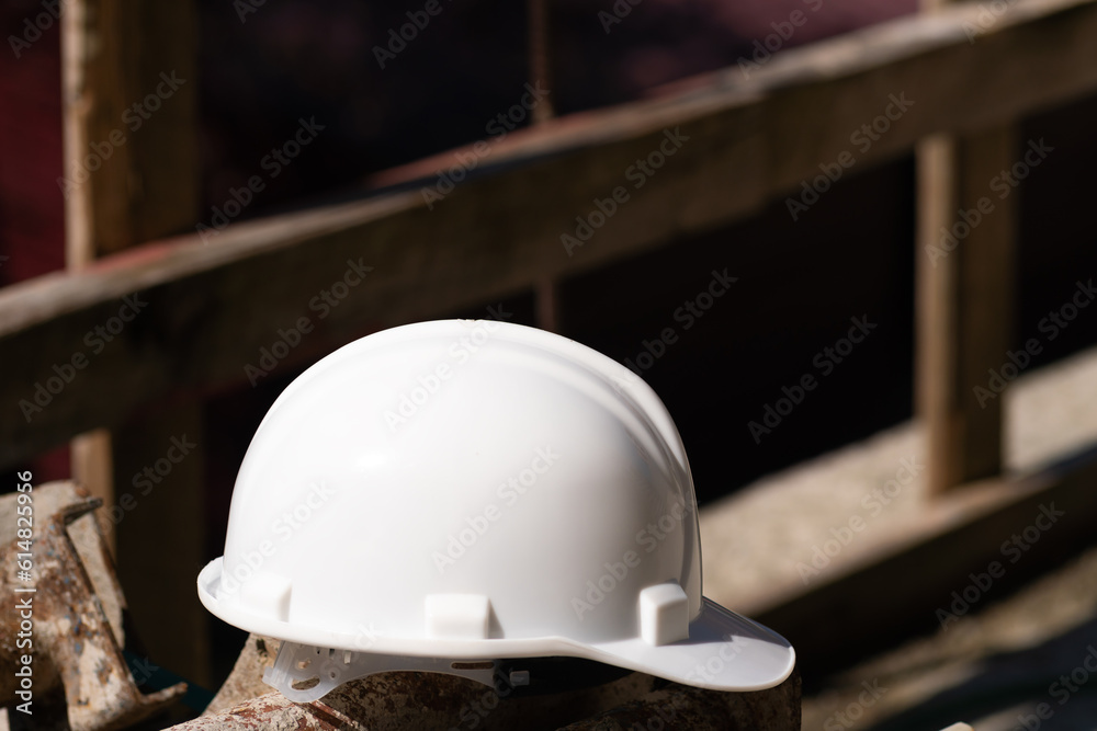 Close-up of a white helmet lying on metal structures on a construction site, safety precautions. Close-up of a white helmet lying on metal structures on a construction site, safety precautions.