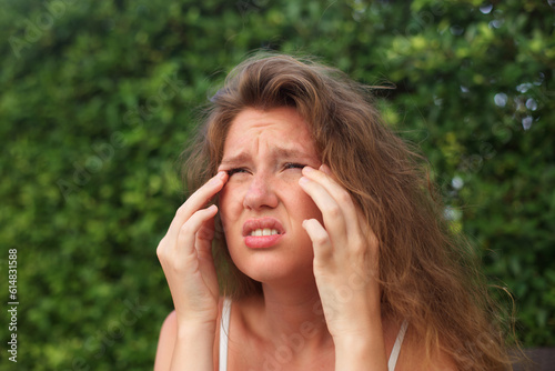 Foto Young woman scratching itchy and rub eyes with her hands in a park, problems wit