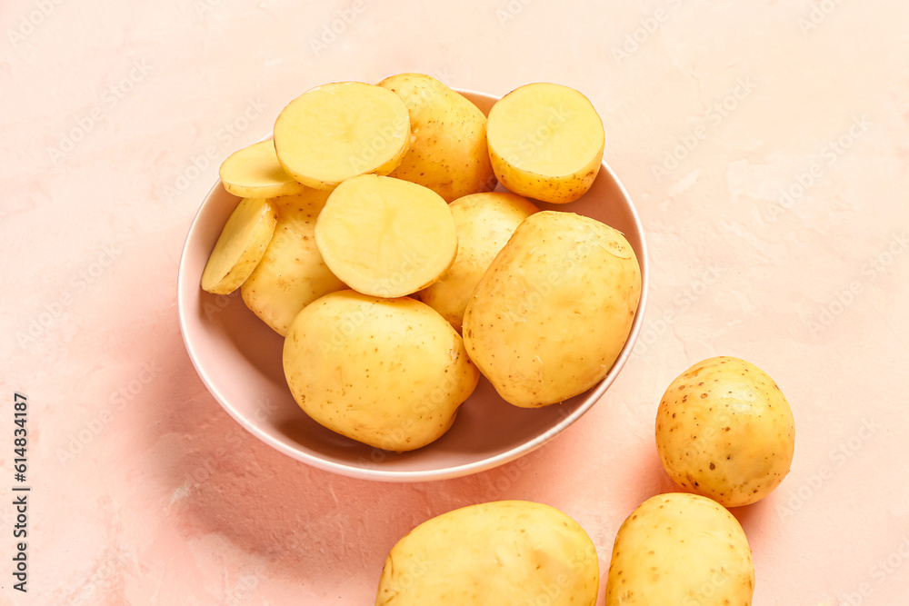 Bowl with raw baby potatoes on pink background Bowl with raw baby potatoes on pink background