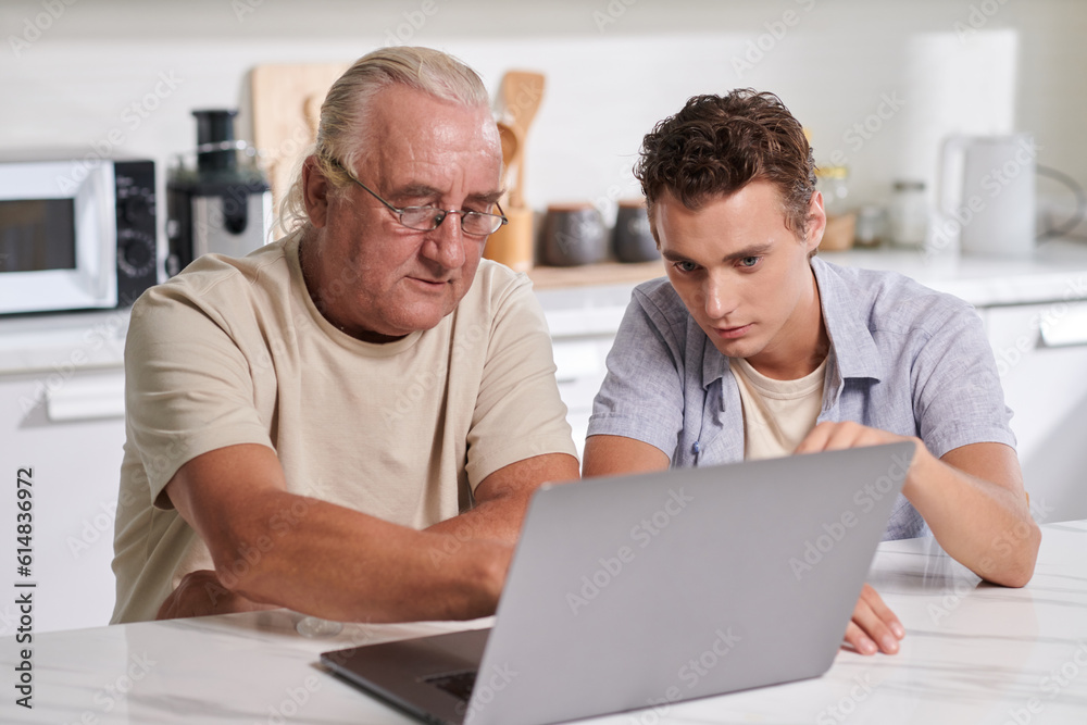 Young man and his grandfather discussing what to order for dinner Young man and his grandfather discussing what to order for dinner