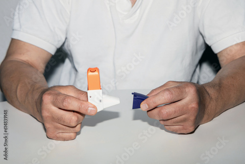 Man holding asthma inhaler in his hands. photo
