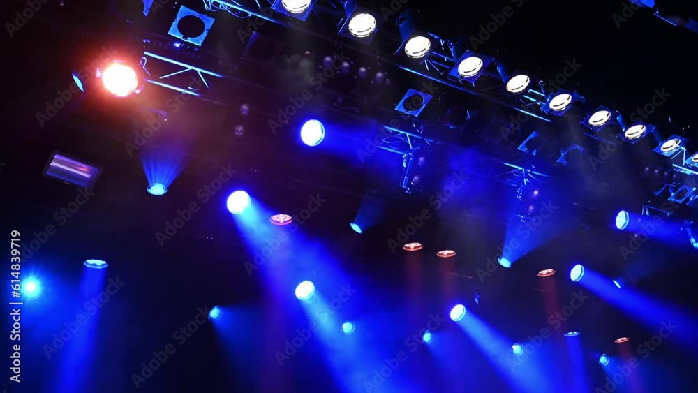 bright blue ceiling spotlights lights the stage through the stage fog during the musical concert or show