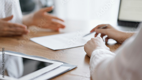 Business people discussing contract signing deal while sitting at the wooden table in office. Partners or lawyers working together at meeting. Teamwork, partnership, success concept