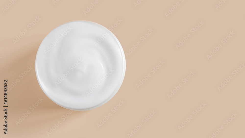 White cream in a jar on a beige background. White cream in a jar on a beige background.