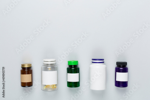 Plastic bottles with vitamins on color background, top view