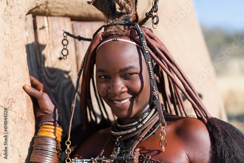 Happy Himba woman smiling, dressed in traditional style at her village in Namibia, Africa. photo