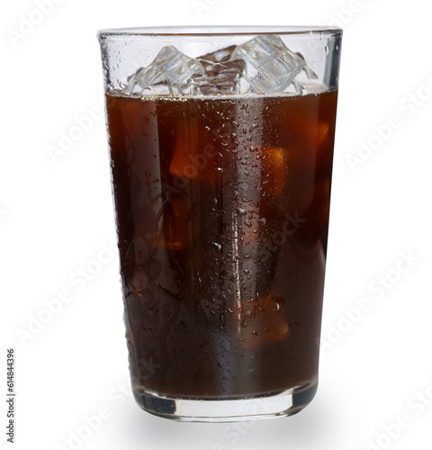 Cold brown drink in tall transparent tall glass with water droplets. Closeup cold iced americano coffee with ice cubes no straw side view isolated on white background. 