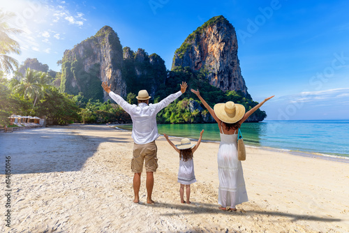 A happy family stands on the beautiful beach of Railay, Krabi, Thailand, during their summer vacations