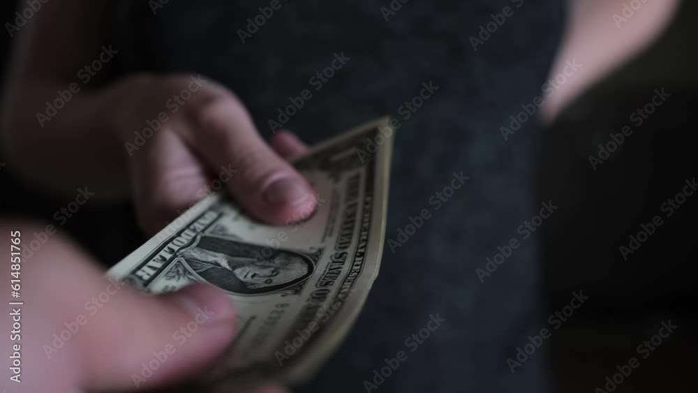 Close-up shot of  housewife hands her husband pack of euro banknotes, angry housewife not though giving money. Women empowerment. Family budget management concept. 
