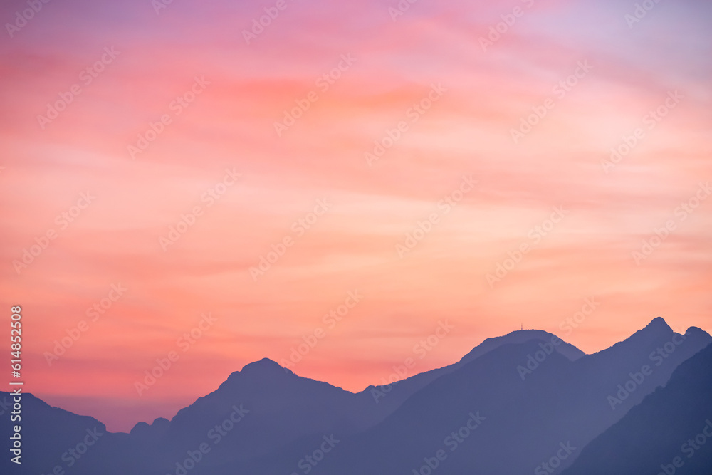 Purple and pink sky over misty mountains silhouette