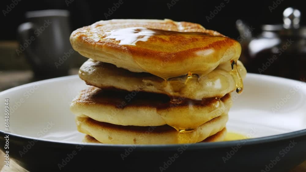 Homemade pancakes in a gray plate poured with honey honey slowly flows into the slow motion plate. Medium plan. Homemade pancakes in a gray plate poured with honey honey slowly flows into the slow motion plate. Medium plan.