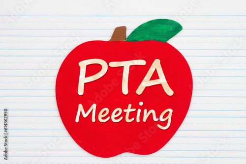 PTA meeting message on a wooden apple on vintage ruled line notebook paper photo