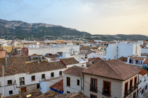 View over the roofs of the old houses of Denia, photographed from the Castle, with a view of the mountains on the horizon.