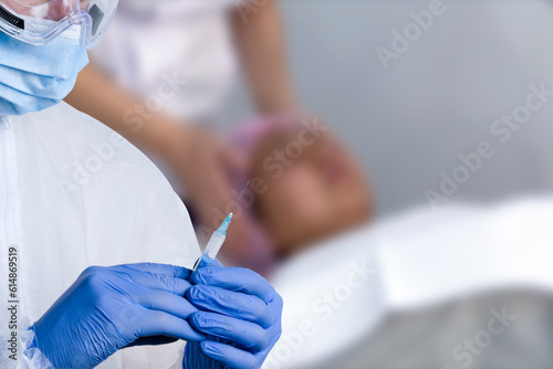 Cosmetologist in sterile gloves holds syringe for injection with collagen hyaluronic filler for face or lips rejuvenation  close up.